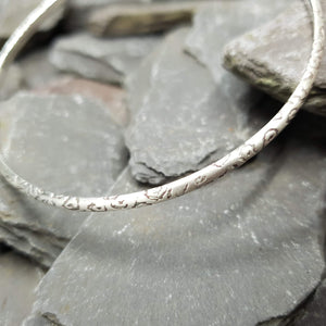 Leopard print acid etched into a sterling silver bangle.