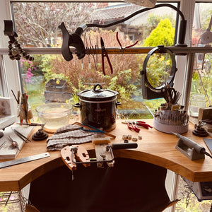 Jewelers workbench with tools and view into garden.