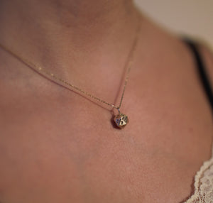 Solid 9ct gold D20 dice on a gold chain being worn by a young lady.