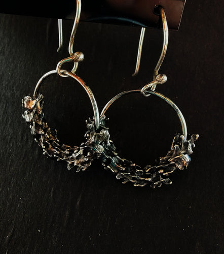 Mini silver vertebra presented on a silver hoop with hook earrings.